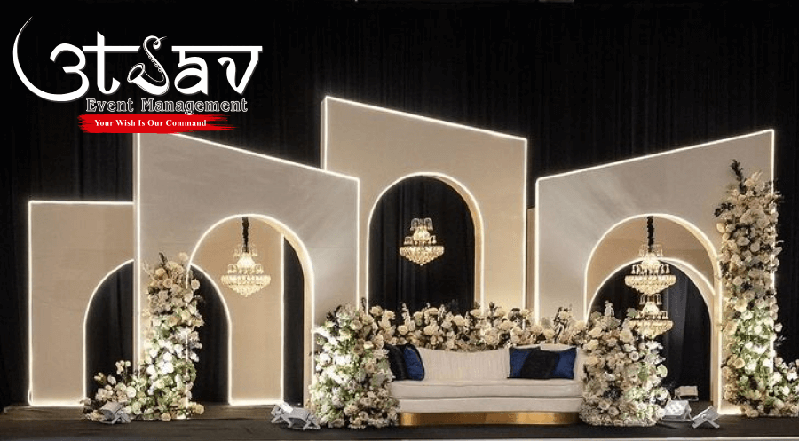 Luxury anniversary and engagement party decoration with modern arch backdrop, floral arrangements, chandeliers, and elegant seating by professional party planners