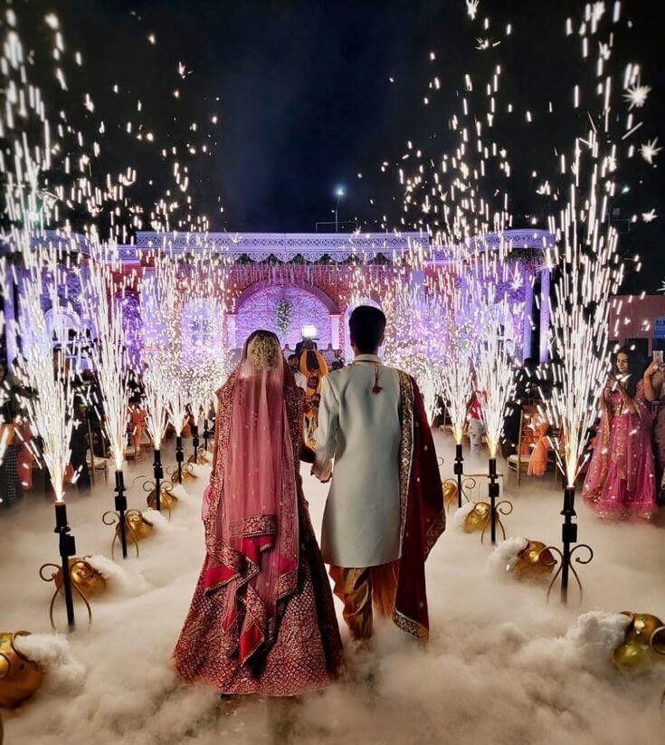 Royal wedding entrance with cold pyros fog effects and luxury stage decoration by professional event planner.